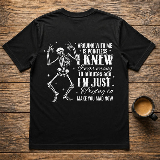 Arguing With Me Is Pointless dancing skeleton graphic on the back of a black Royal Arms USA tee, flat lay