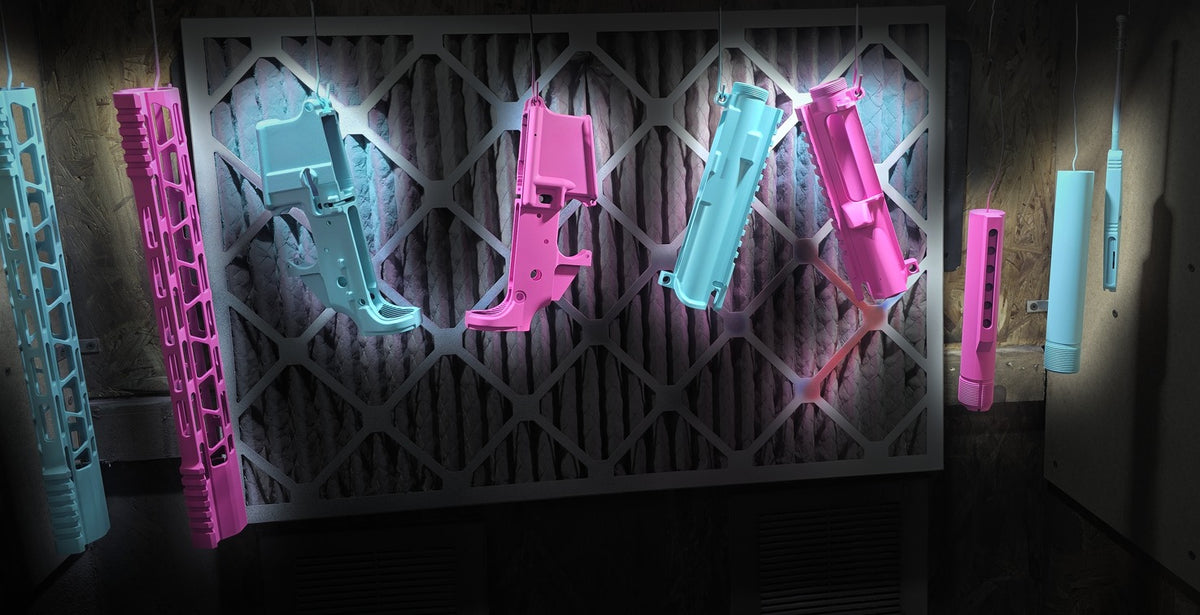Cerakote in progress - teal and pink AR parts in the booth